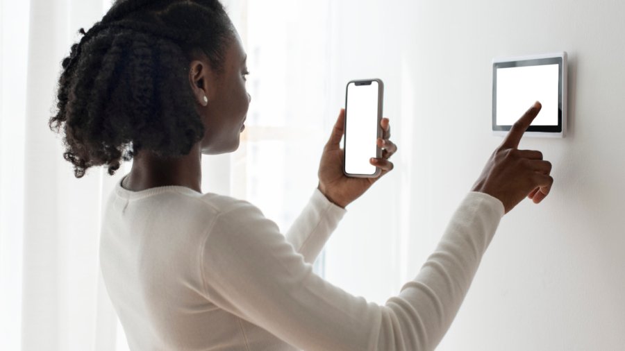 Woman pressing on smart home automation panel monitor